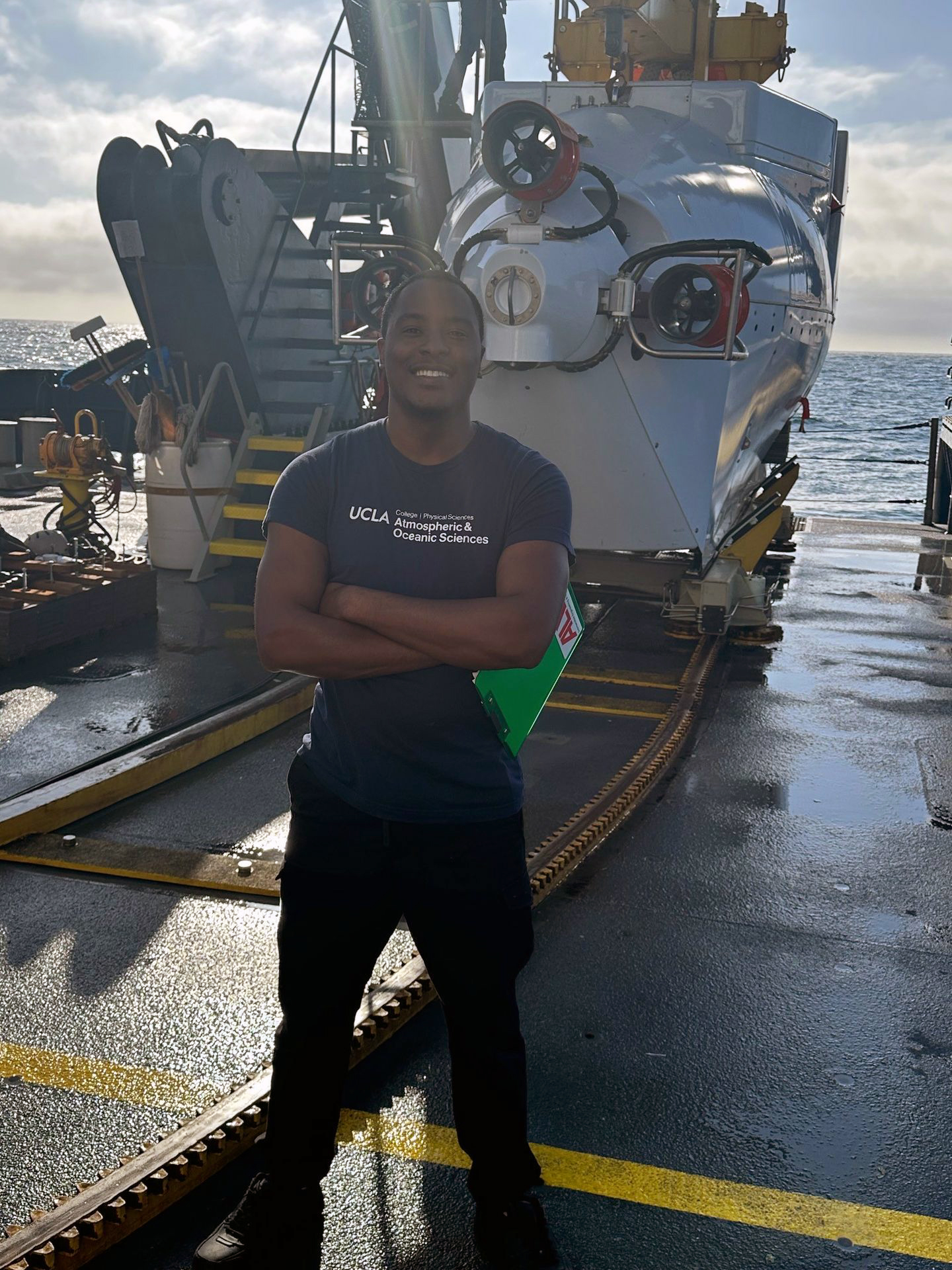 De’Marcus Robinson smiling on the deck of a research vessel in the Santa Barbara Basin.