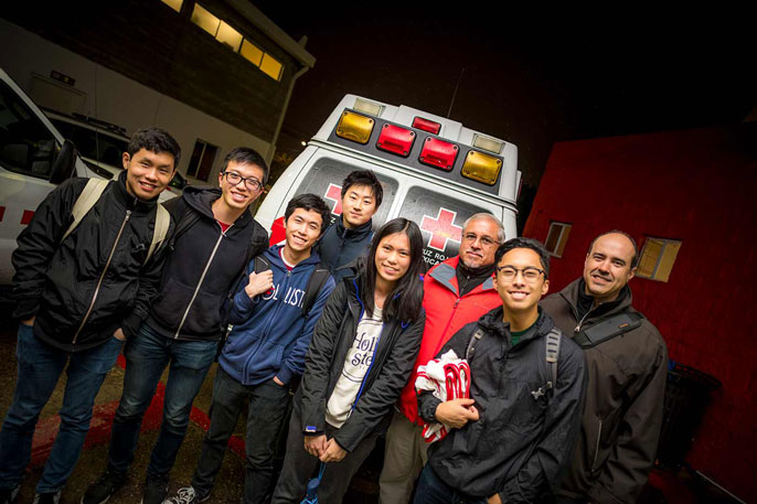 Students stand in front of an ambulance