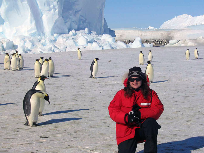 Meir in front of a bunch of penguins in Antarctica