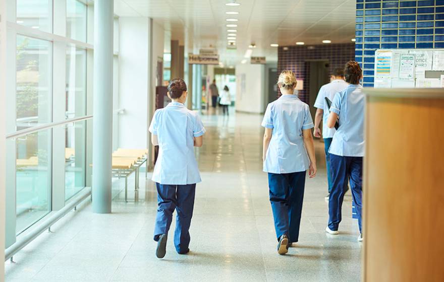 Nurses in a hospital hallway, walking away