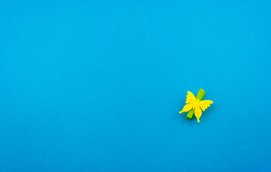 Yellow paper butterfly on blue background