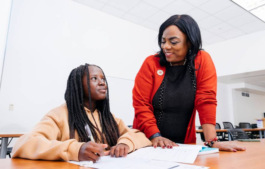 Ingrid Johnson, founder of CAAP, talks to a student taking a test in a classroom