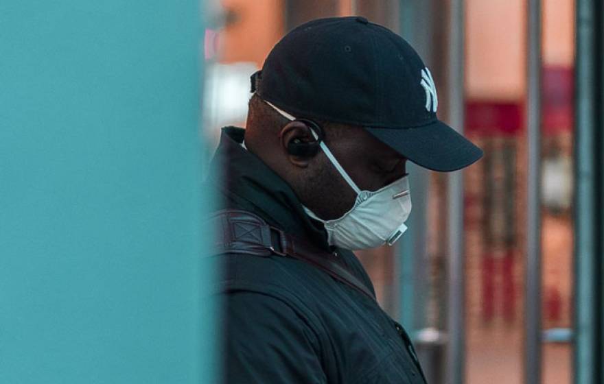 Black man wearing respirator mask outside