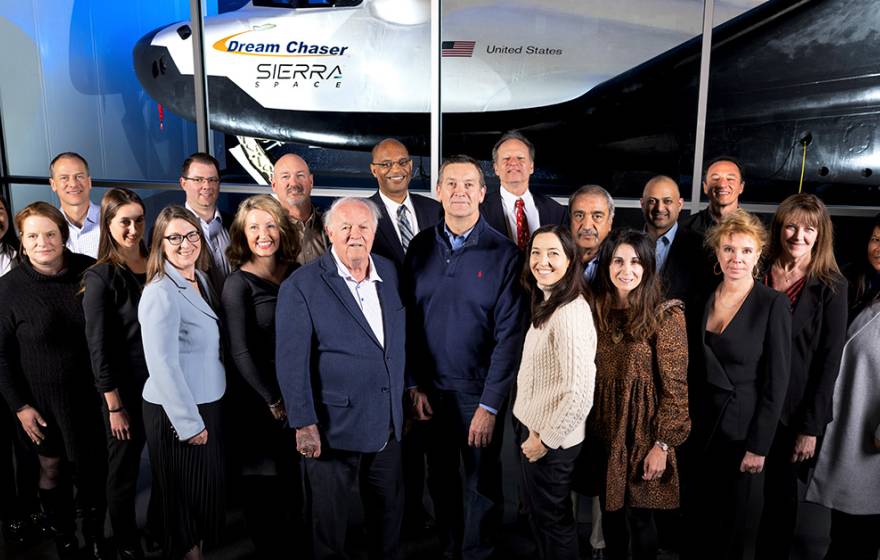 Group photo in front of a space vehicle