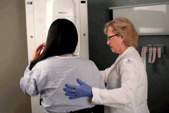 Researcher helping patient at a machine