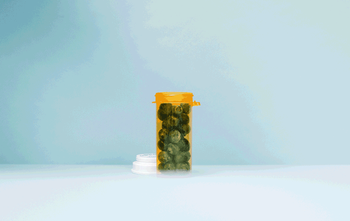 Blueberries tumbling into a pill bottle