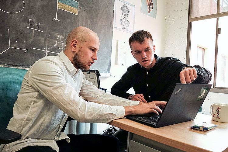 Igor Molybog (left) and Maksym Zubkov (right) working together on support strategy for Ukraine at a computer