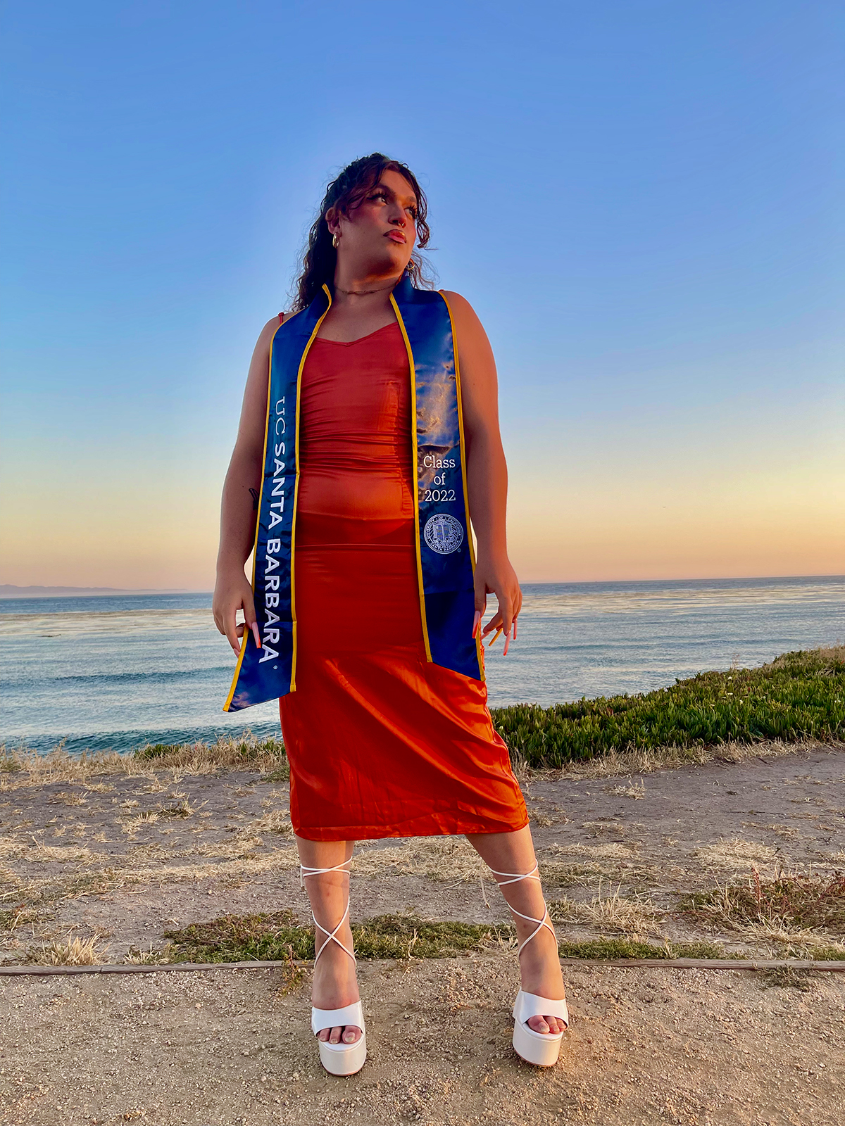Esme Quintero-Cubillan in graduation stole by the beach