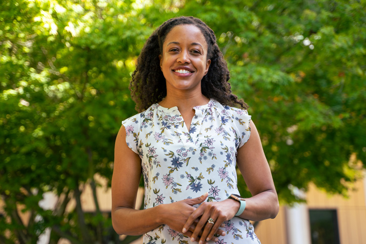 Young Black woman, Melinda Kliegman, in flowered blouse outside by tree