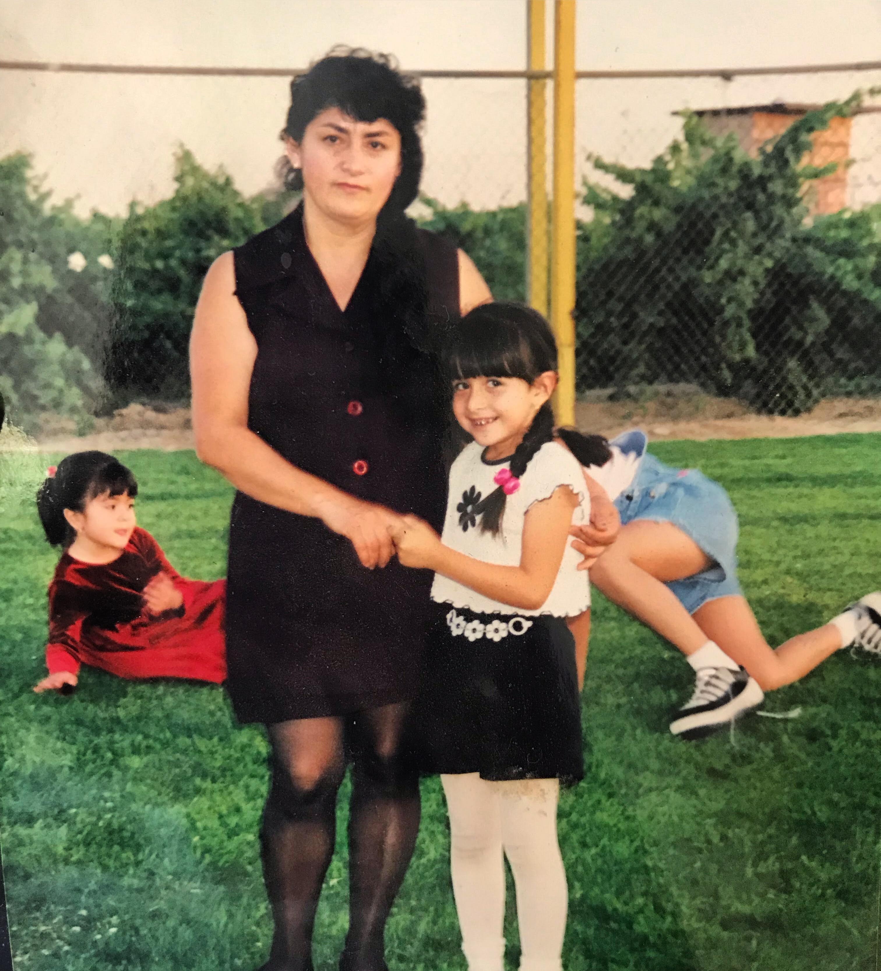 A young Rosa Mora stands with her mom