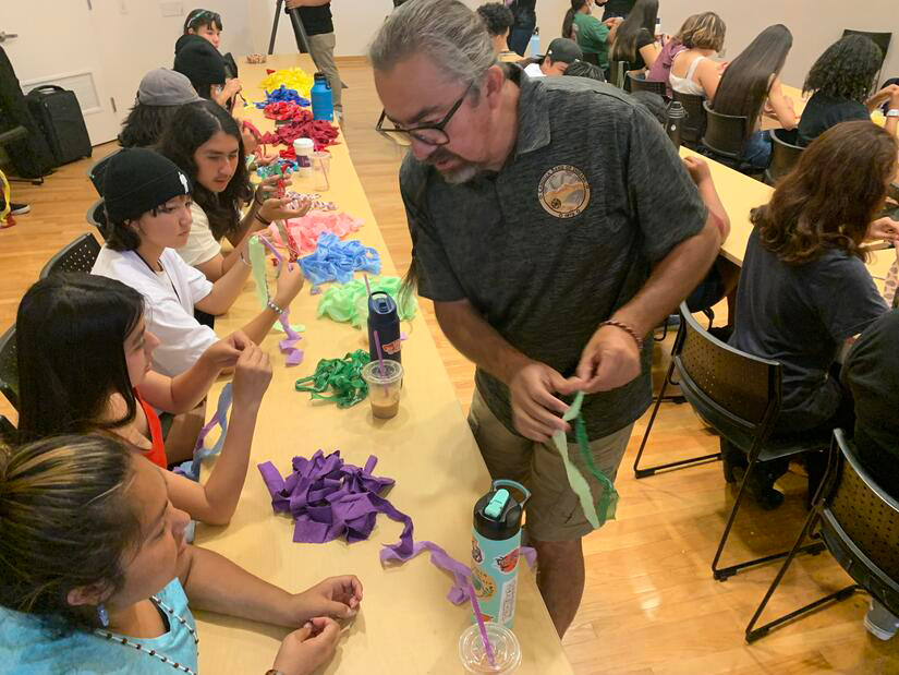 Man helping students on a project in a classroom