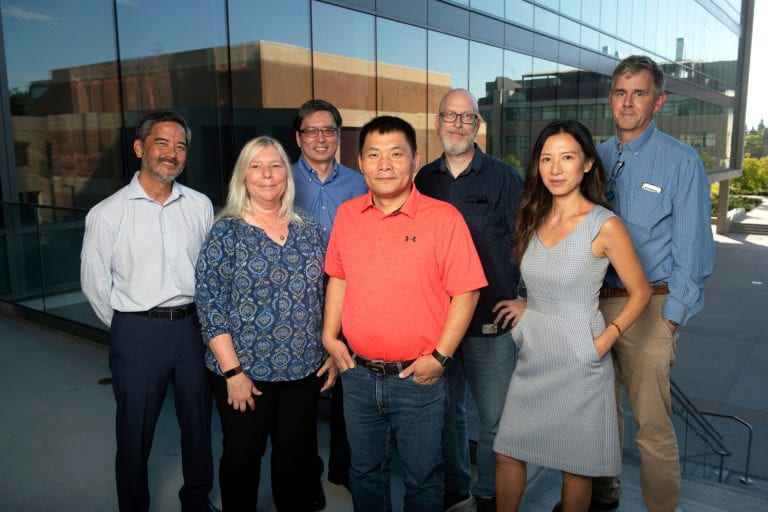 Team of scientists pose outside