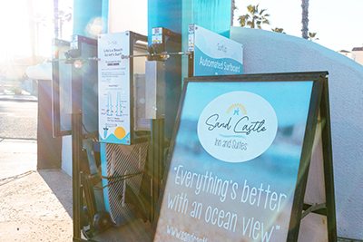 A rack of surfboards for rent with a placard