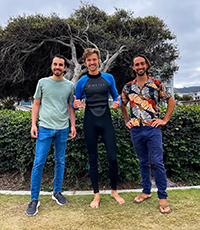Three men, one in a wetsuit