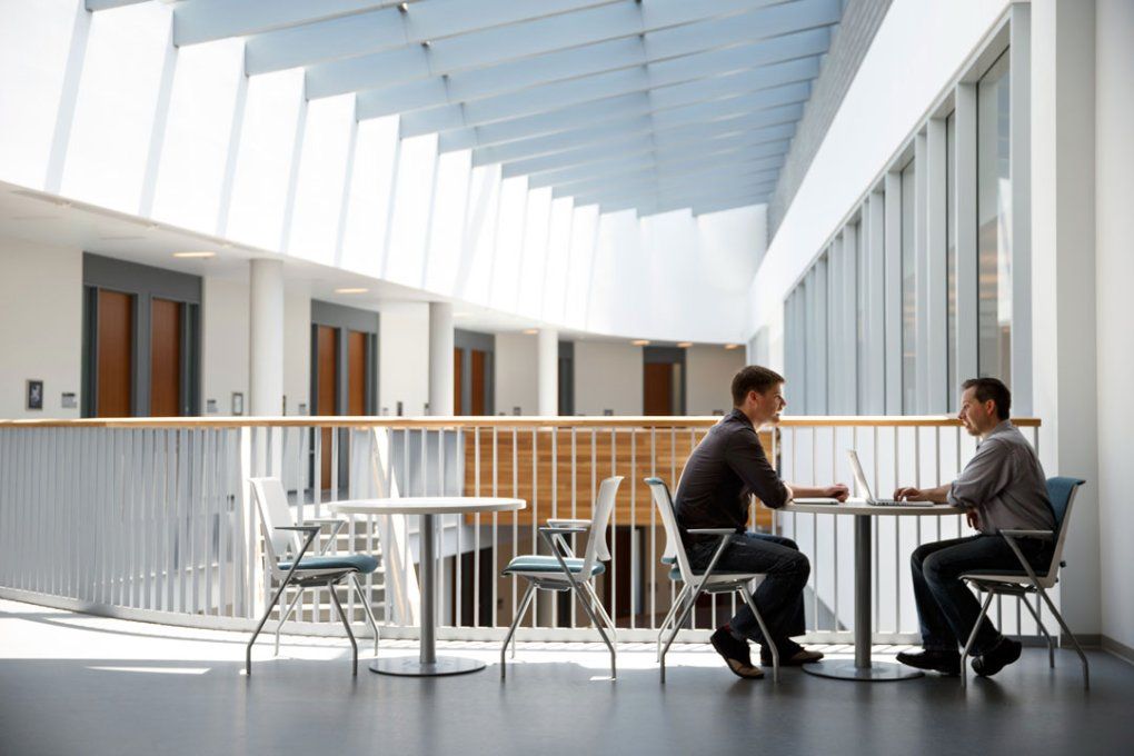 Two men seated at a table talking at UCSF