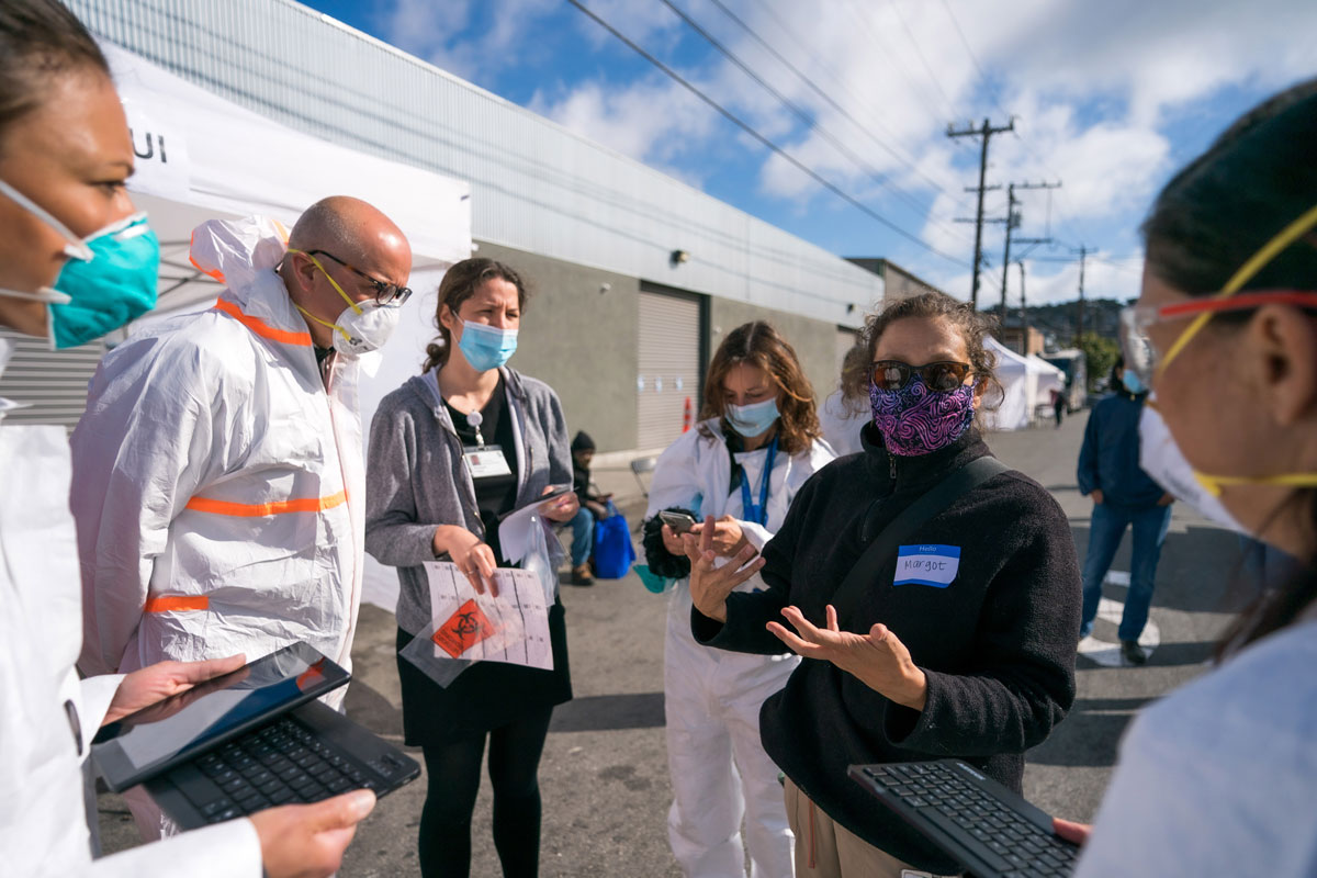 A group of people outside in PPE