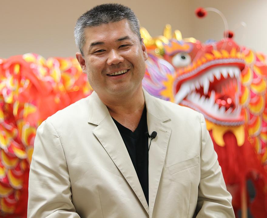 Henry Huang with a Chinese New Year dragon behind him