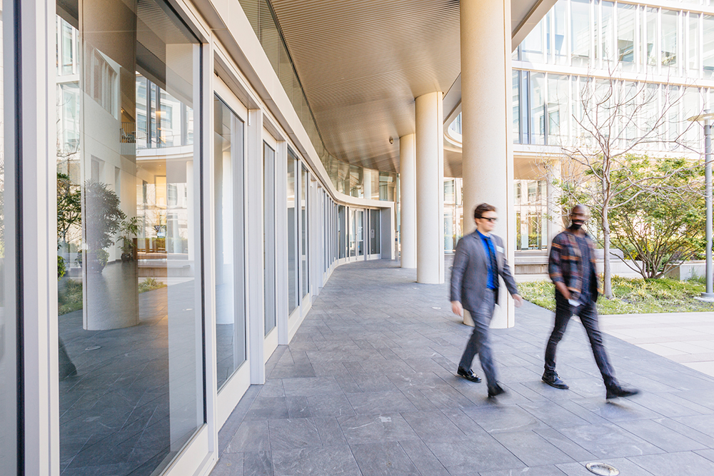 A white man and a Black man walking on the UCSF campus