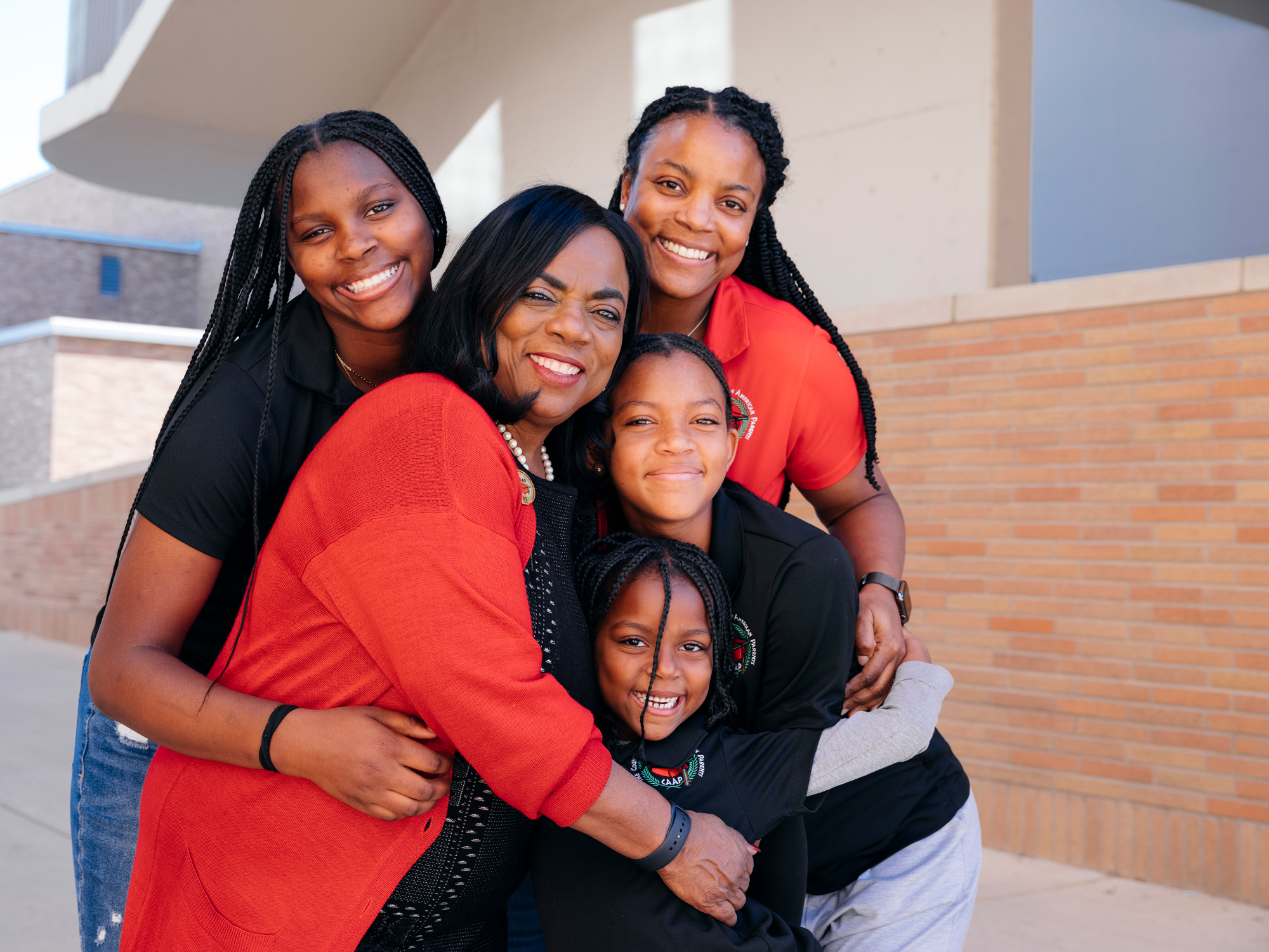 Ingrid Johnson, Raquel Rall, and Rall's three children hug
