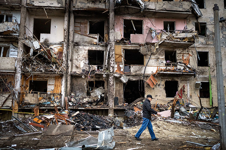 Man walking by a bombed out building