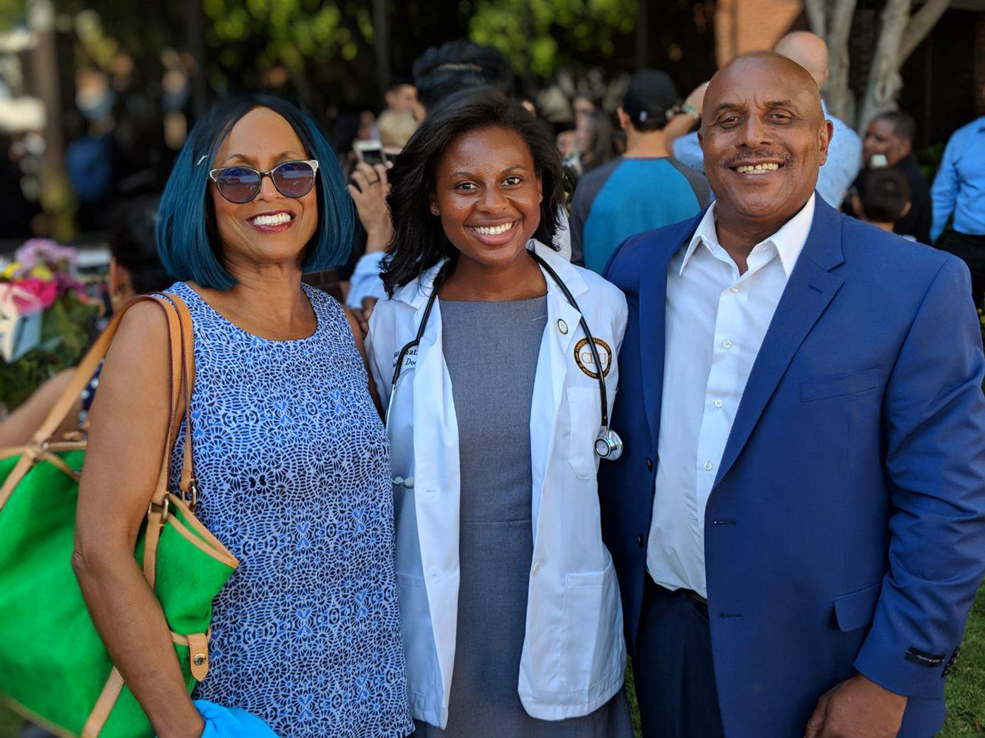 Janae Chatmon flanked by her aunt and father at the white coat ceremony