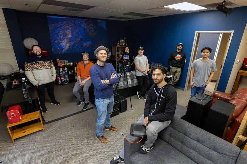 Group of people in a room together with projected backdrop