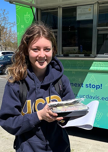 Alexandra Sarimsakci holding a to-go order from the food truck