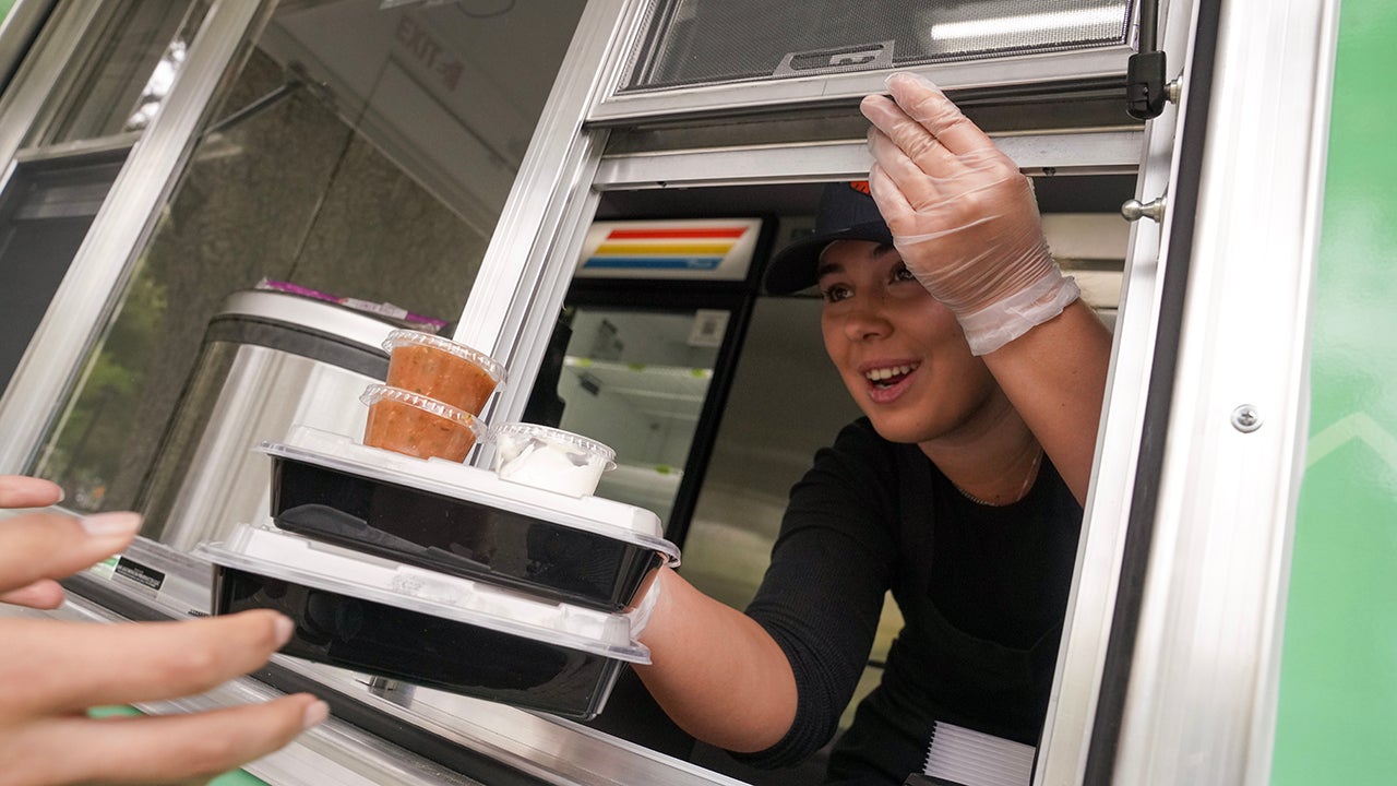 Smiling woman serving meals through the food truck window