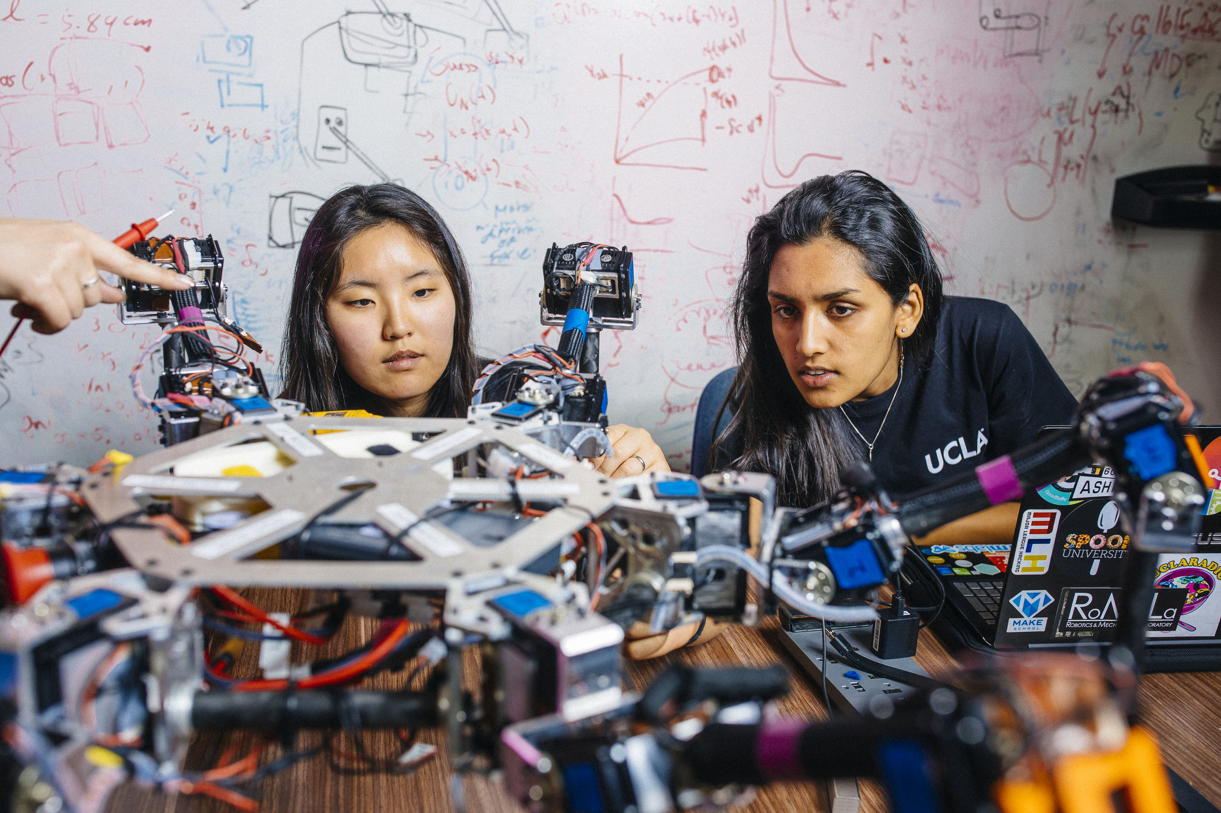 Two women in an engineering lab look at a project