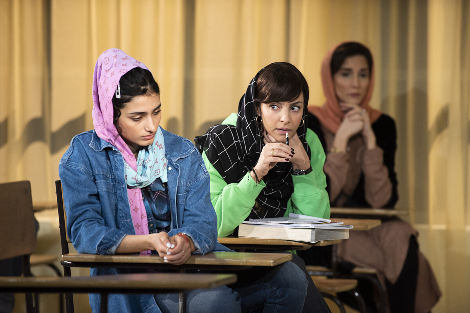 A scene from Sanaz Toossi's play English, with three Iranian women in hijabat desks