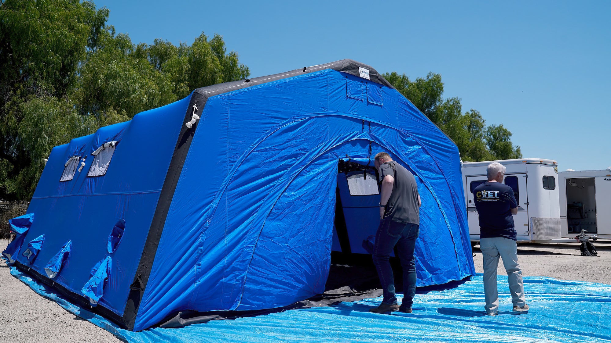 A giant blue tent with a man in front of it