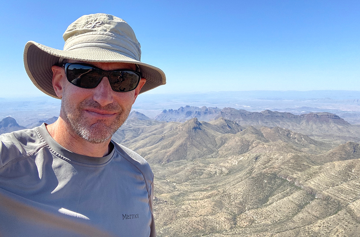 Kurt Cuffey selfie in the outdoors, dry canyon behind