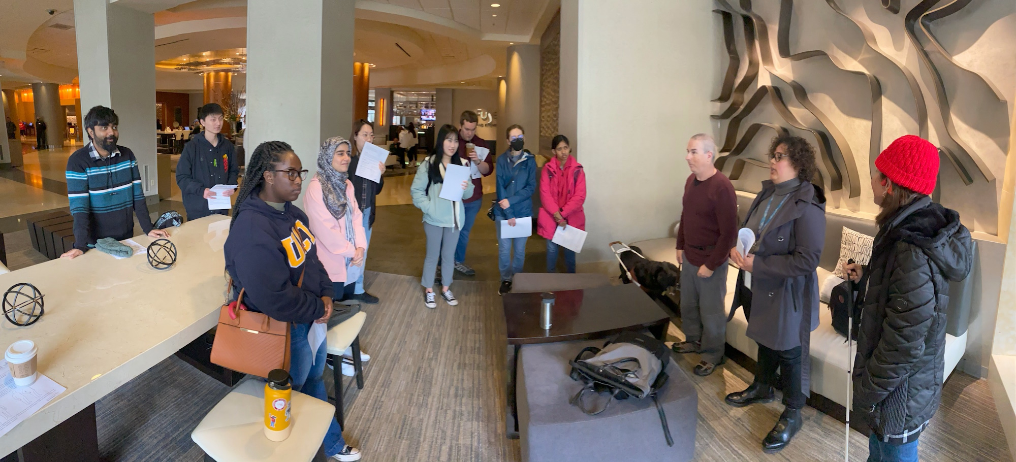 A group of students listening to someone at the head of a conference room