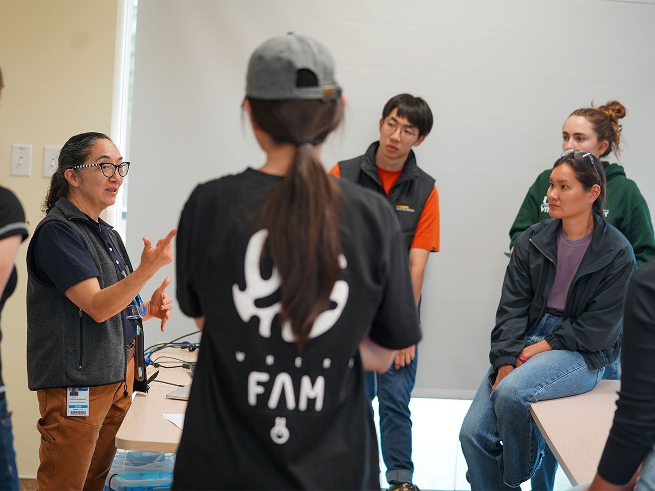 A Latina instructor and winemaker speaks to a small group of students