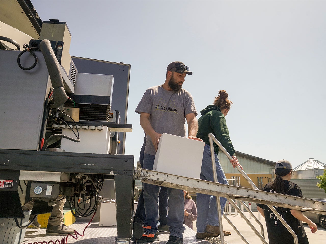 A man and a female student take boxes out of a truck