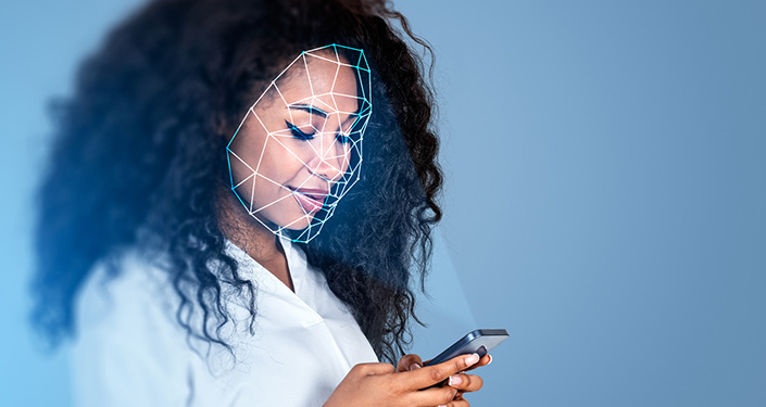 a person looking at a phone with a drawing of facial recognition lines and points overlaid on her face