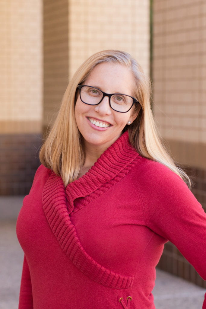 Jessica Borelli, blonde woman with long hair and glasses, smiling