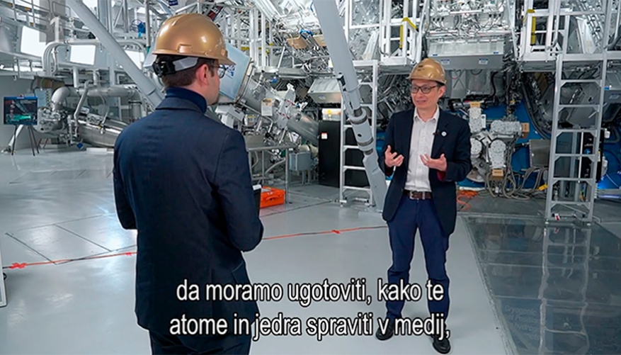 Two people talking in the lab wearing gold hard hats