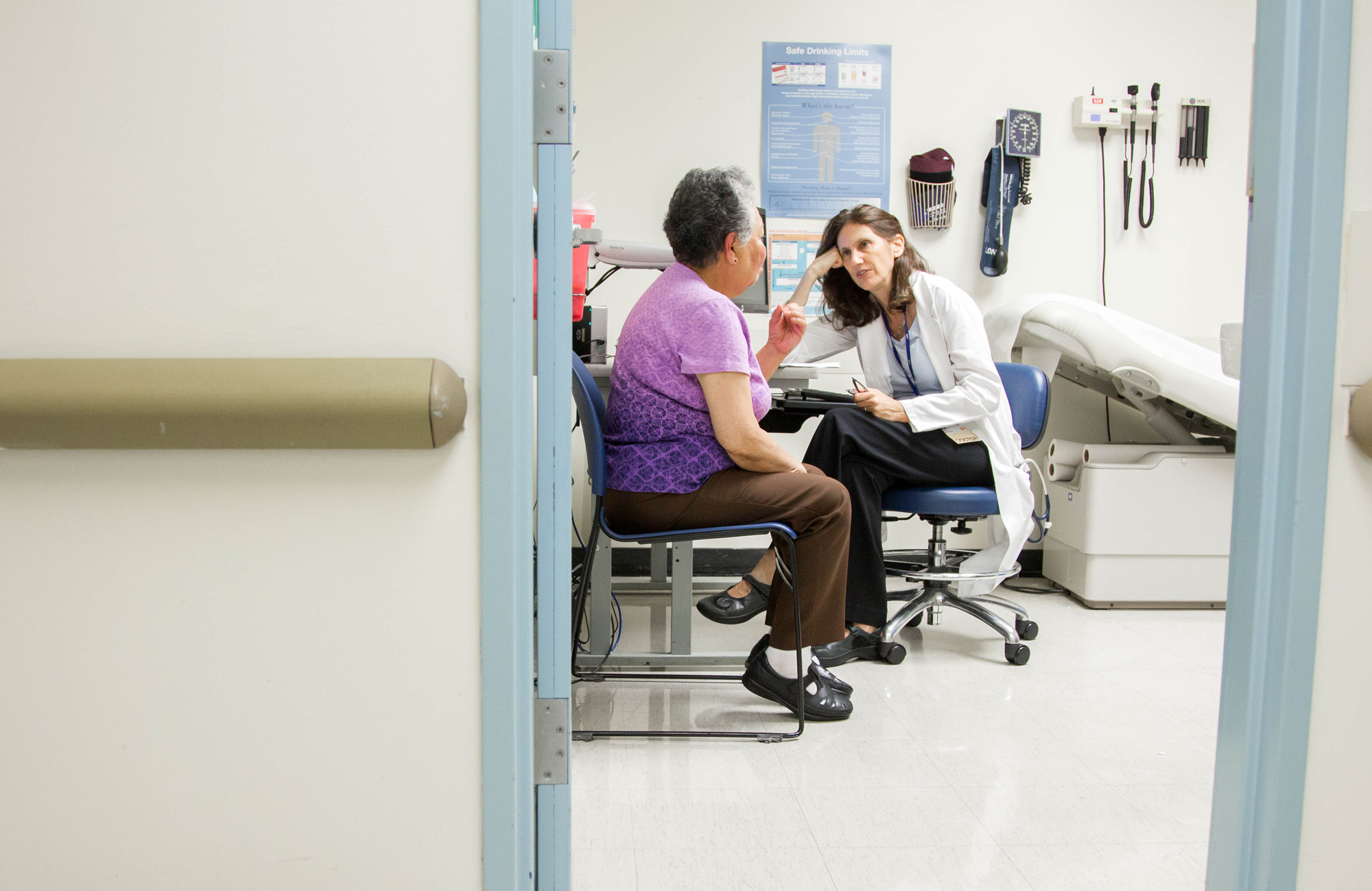 A doctor talks to a patient in a hospital examination room