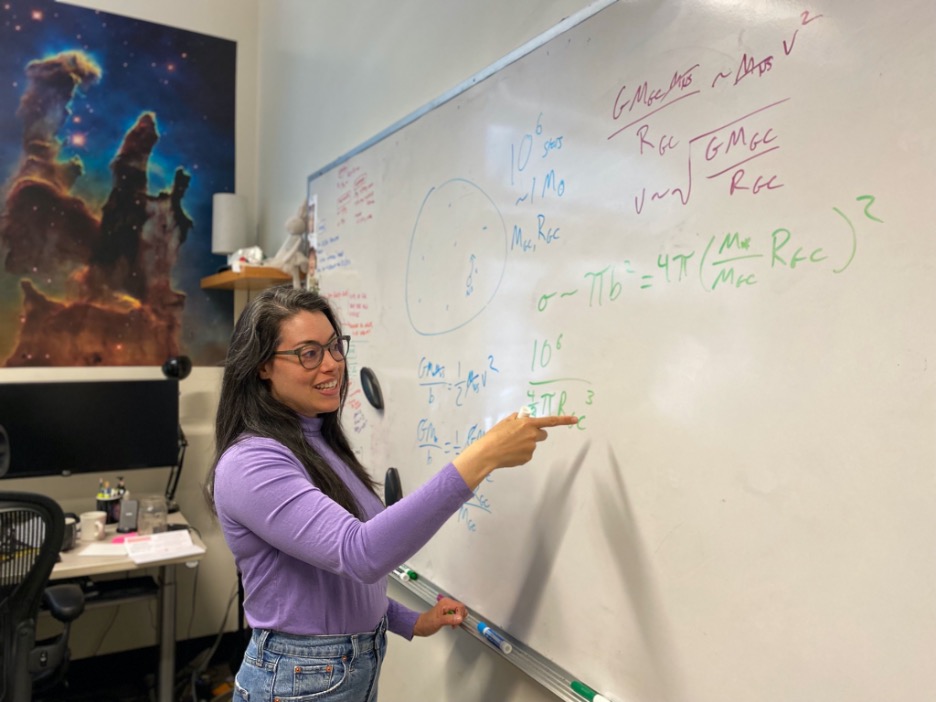 Rosa W. Everson, a young Latina woman with dark hair, at a whiteboard, pointing