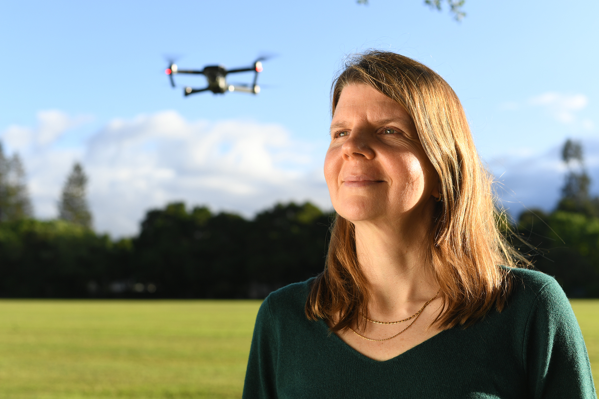 A blonde woman with a drone behind her
