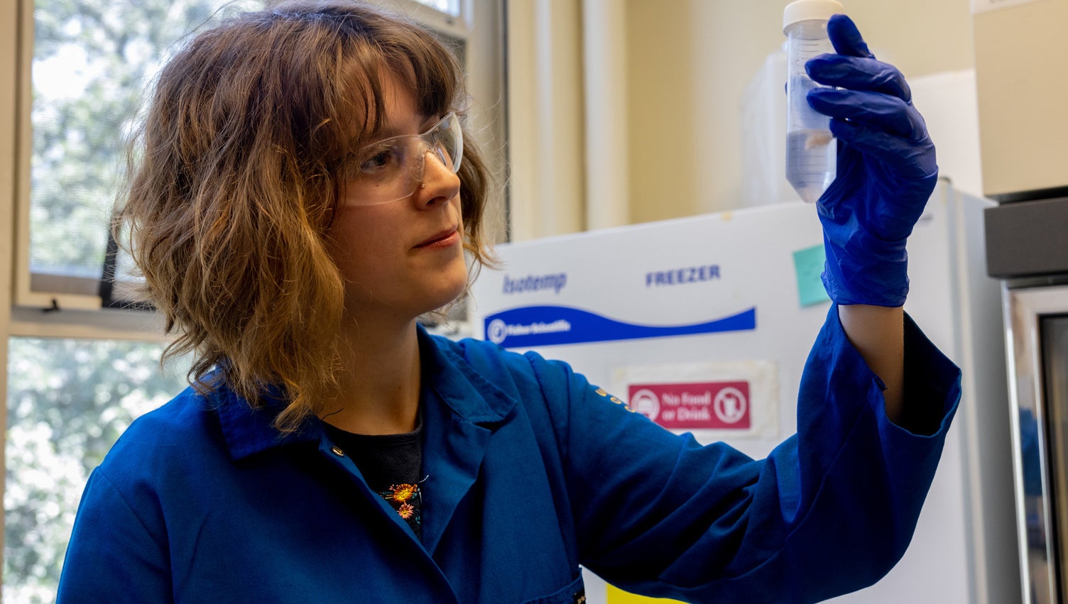 Young white woman with a bob holds up a pipette