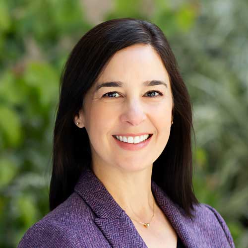 Portrait of Margo Pumar, straight dark brown hair, wearing a purple blazer