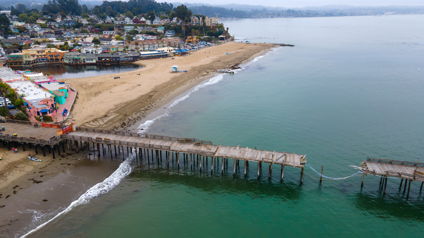Aerial view of Capitola Beach with a damaged pier in the foreground