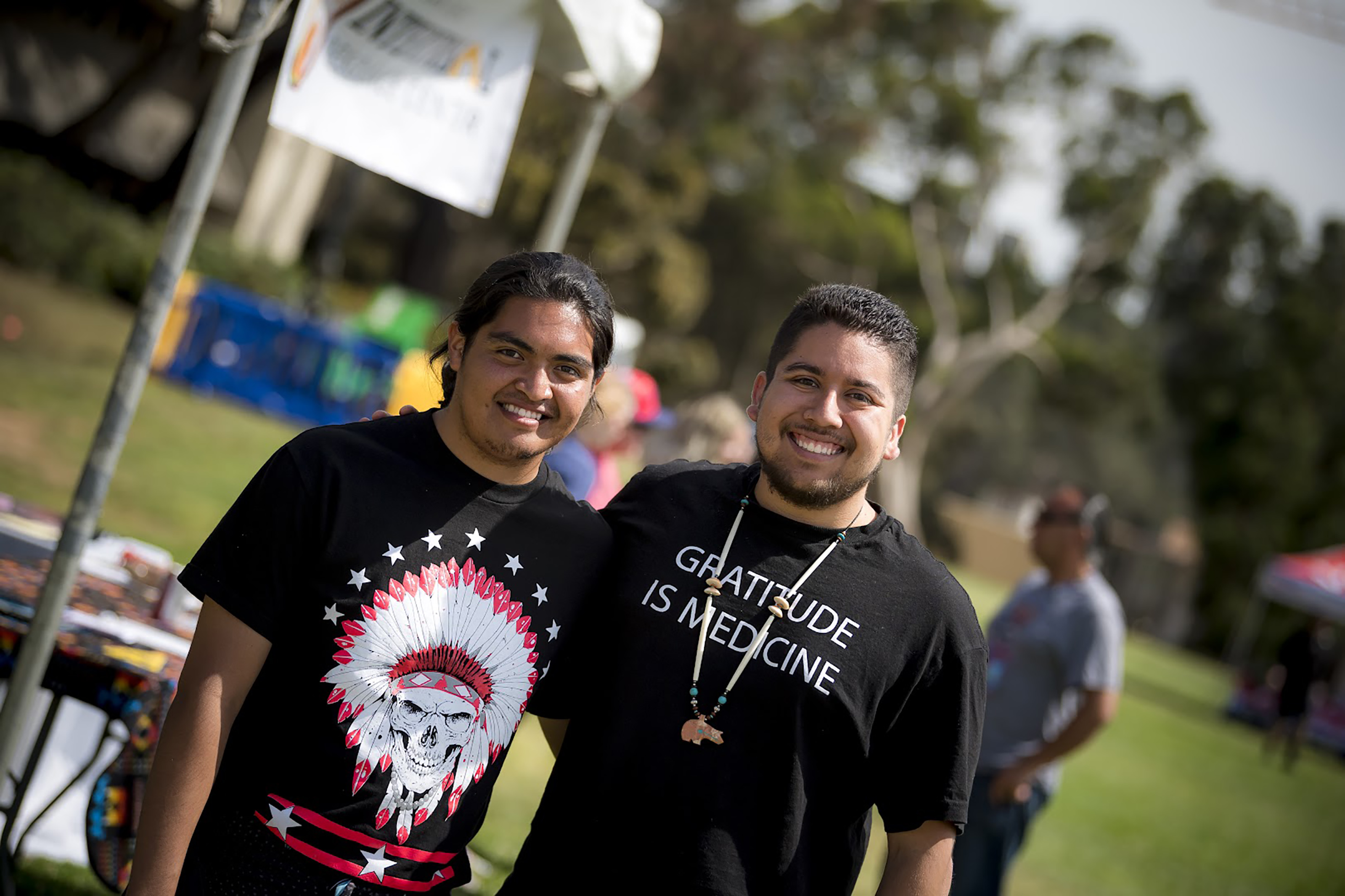 Two young Native American men standing together on campus