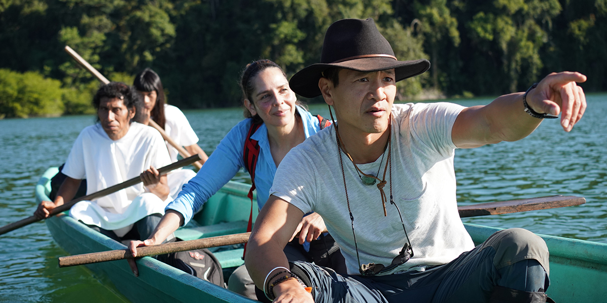 Albert Lin, front, in fedora, with three people behind him in a rowboat