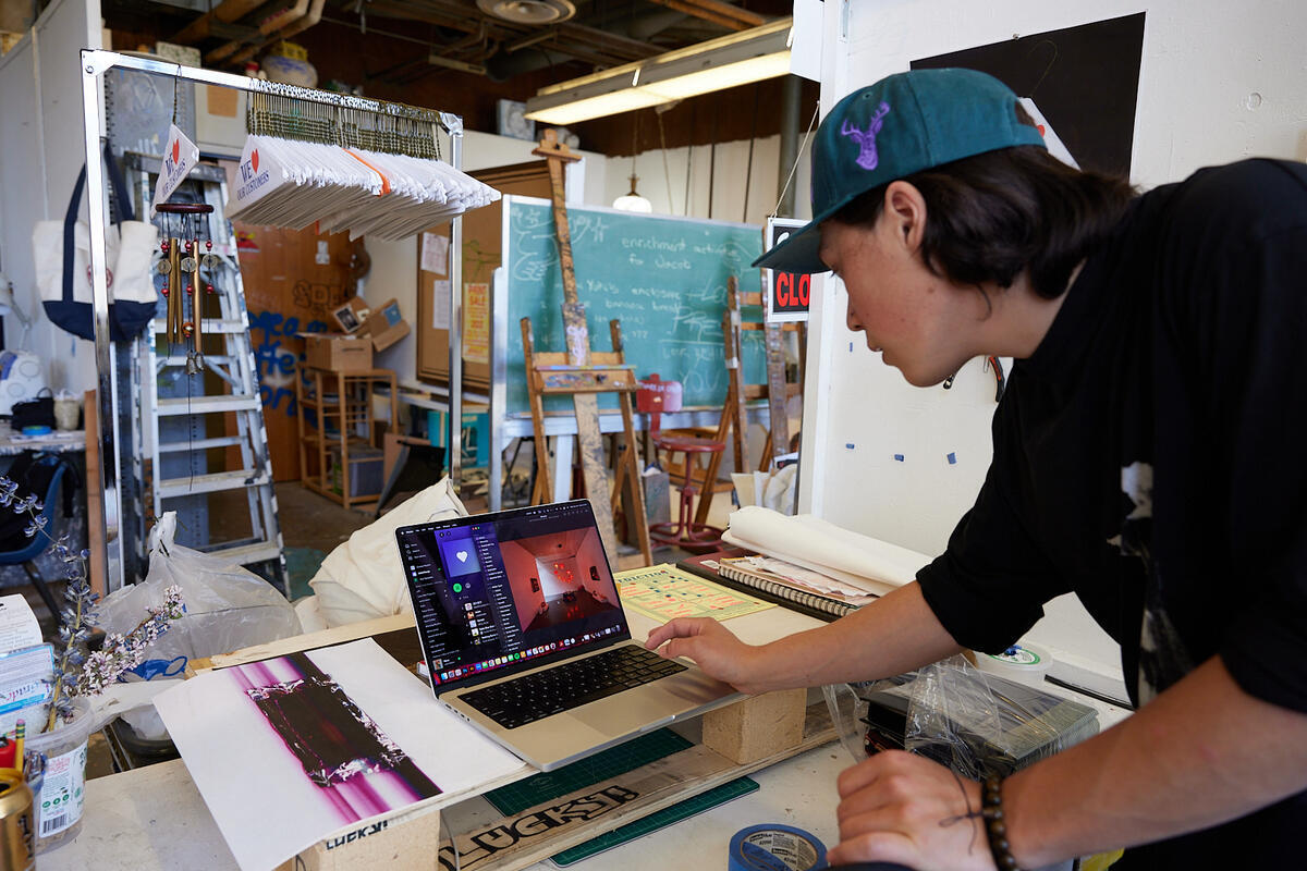 A student in an art studio working on a computer