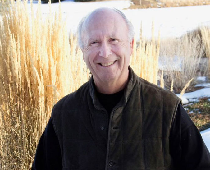 Smiling white senior man, David P. Gardner, outdoors during winter, snow and yellow grasses behind him