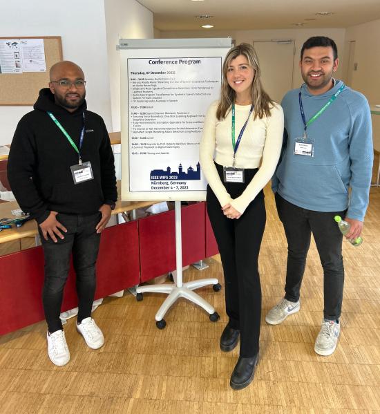 Three student researchers at a conference