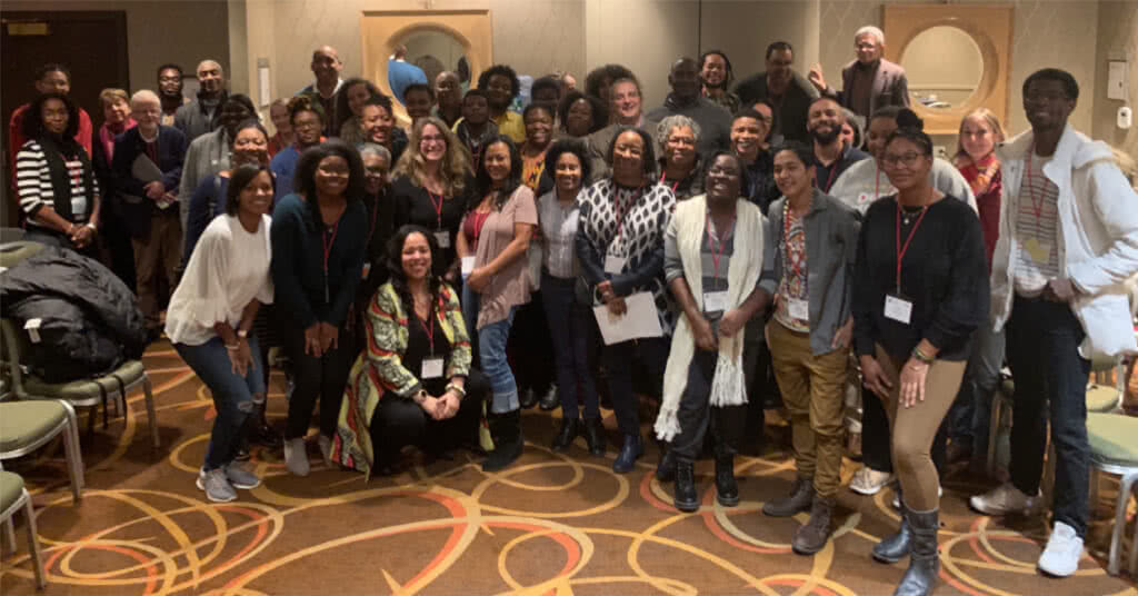 A large group photo of members of the Society of Black Archaeologists in a conference room